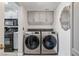 Conveniently located laundry area with gray cabinets and a modern washer and dryer at 7984 Laurena Ave, Las Vegas, NV 89147