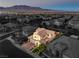The house's aerial view is seen in the foreground with mountains in the distance at 8126 Majestic Bighorn St, Las Vegas, NV 89166