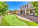 Beautiful backyard featuring a putting green, covered patio, and outdoor seating area, perfect for entertaining at 8126 Majestic Bighorn St, Las Vegas, NV 89166