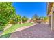 Spacious backyard with a manicured putting green bordered by brick pavers and lush landscaping at 8126 Majestic Bighorn St, Las Vegas, NV 89166