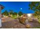 Paver patio featuring a built-in seating area, modern fire pit, and a putting green at 8126 Majestic Bighorn St, Las Vegas, NV 89166