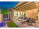 Stylish outdoor patio featuring a seating area, artificial turf, and a view of the home's interior at 8126 Majestic Bighorn St, Las Vegas, NV 89166