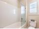 Bathroom featuring a shower over tub with glass partition and white toilet at 8126 Majestic Bighorn St, Las Vegas, NV 89166