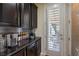Elegant butlers pantry with dark cabinetry and seamless access to the outdoors at 8126 Majestic Bighorn St, Las Vegas, NV 89166
