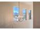 Stunning chandelier hangs in a bright hallway, with large windows overlooking the neighborhood at 8126 Majestic Bighorn St, Las Vegas, NV 89166