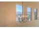 Elegant chandelier with mountain view through a window in a high ceiling at 8126 Majestic Bighorn St, Las Vegas, NV 89166