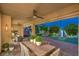 Charming covered patio featuring a ceiling fan, dining table, seating, and a landscaped backyard at 8126 Majestic Bighorn St, Las Vegas, NV 89166