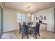 Dining room features a modern chandelier, a round glass table, and views to the backyard at 8126 Majestic Bighorn St, Las Vegas, NV 89166