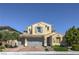 Inviting two-story home featuring a three-car garage, manicured lawn, and charming architectural details at 8126 Majestic Bighorn St, Las Vegas, NV 89166