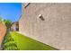 Exterior side view of the home with green turf and manicured landscaping along the wall at 8126 Majestic Bighorn St, Las Vegas, NV 89166