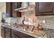 Close-up showcasing a gas range with a stylish backsplash, granite countertops, and modern cabinetry at 8126 Majestic Bighorn St, Las Vegas, NV 89166
