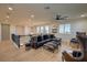 Living area with hardwood floors, ceiling fan, leather sofa and accent chairs by large windows at 8126 Majestic Bighorn St, Las Vegas, NV 89166