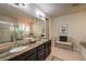 A luxurious bathroom with dual sinks, granite countertops, a soaking tub, and a glass-enclosed shower at 8126 Majestic Bighorn St, Las Vegas, NV 89166
