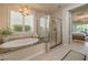 A spacious bathroom showcases a tub, shower, and a view of the backyard at 8126 Majestic Bighorn St, Las Vegas, NV 89166