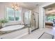 Bright main bathroom with a soaking tub, a glass enclosed shower, and a view of the main bedroom at 8126 Majestic Bighorn St, Las Vegas, NV 89166