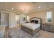A bright main bedroom features a large bed, a decorative chandelier, and access to the bathroom at 8126 Majestic Bighorn St, Las Vegas, NV 89166