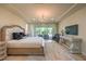 A bright main bedroom features a large bed, a decorative chandelier, and access to the backyard at 8126 Majestic Bighorn St, Las Vegas, NV 89166