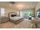 A bright main bedroom features a large bed, a decorative chandelier, and access to the backyard at 8126 Majestic Bighorn St, Las Vegas, NV 89166