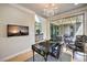 Open office features a chandelier, floral desk, and sliding glass doors leading to a patio at 8126 Majestic Bighorn St, Las Vegas, NV 89166