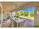 Inviting covered patio with ceiling fan and view of a backyard featuring a putting green and water feature at 8126 Majestic Bighorn St, Las Vegas, NV 89166