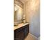Elegant powder room featuring a decorative mirror and stylish vanity with a light countertop and dark wood cabinet at 8126 Majestic Bighorn St, Las Vegas, NV 89166
