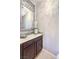 Powder room with a decorative mirror and accent wallpaper at 8126 Majestic Bighorn St, Las Vegas, NV 89166