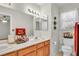 Bright bathroom includes double sinks, a large mirror, toilet, and a window at 8316 Vibrant Dr, Las Vegas, NV 89117