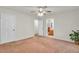 A well-lit bedroom featuring a ceiling fan, an open door, and carpeted floors at 8316 Vibrant Dr, Las Vegas, NV 89117