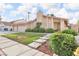 Inviting home exterior featuring a lush lawn, stone walkway, and mature landscaping at 8316 Vibrant Dr, Las Vegas, NV 89117