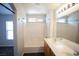 Bright bathroom with a double sink vanity and a bathtub featuring white tile surround and a shower fixture at 9526 Borough Park St, Las Vegas, NV 89178