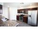 Modern kitchen boasts stainless steel appliances, granite counters, and dark wood cabinetry at 9526 Borough Park St, Las Vegas, NV 89178