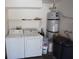 Laundry area with a washer, dryer, water heater, and shelving for storage at 9526 Borough Park St, Las Vegas, NV 89178