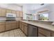 This kitchen has light wood cabinets, stainless appliances, and tile flooring with backyard views at 9812 Folsom Dr, Las Vegas, NV 89134