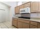 A kitchen with natural wood cabinets, a microwave, and a built in cooktop at 9812 Folsom Dr, Las Vegas, NV 89134