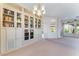 Bright living room with built-in bookcase, chandelier, and large windows for lots of natural light at 9812 Folsom Dr, Las Vegas, NV 89134