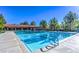 Large outdoor community pool with lane markers, sun loungers, and mature trees at 9812 Folsom Dr, Las Vegas, NV 89134