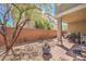 Private backyard featuring a brick wall, trees, and a patio area perfect for outdoor gatherings and relaxation at 9822 Opal Bridge Ct, Las Vegas, NV 89178