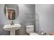 Clean bathroom with a pedestal sink, toilet, and a sleek shelving unit for storage at 9822 Opal Bridge Ct, Las Vegas, NV 89178