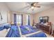 Cozy bedroom space with a ceiling fan, dresser, and natural light streaming through the window at 9822 Opal Bridge Ct, Las Vegas, NV 89178