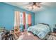 Bright blue bedroom featuring a ceiling fan, neutral carpet, and lots of natural light coming in the window at 9822 Opal Bridge Ct, Las Vegas, NV 89178