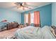 Bright blue bedroom featuring a ceiling fan, neutral carpet, and lots of natural light coming in the window at 9822 Opal Bridge Ct, Las Vegas, NV 89178