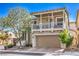 Charming two-story home boasts a covered balcony, tan siding, and a well-manicured front yard at 9822 Opal Bridge Ct, Las Vegas, NV 89178