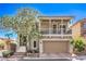 Charming two-story home boasts a covered balcony, tan siding, and a well-manicured front yard at 9822 Opal Bridge Ct, Las Vegas, NV 89178