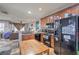 Charming kitchen featuring wood cabinets, black appliances, and an adjacent dining area at 9822 Opal Bridge Ct, Las Vegas, NV 89178