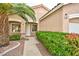 Inviting front of the house featuring lush greenery, desert landscaping, and a covered front entryway at 10017 Snow Crest Pl, Las Vegas, NV 89134