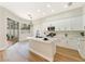 Well-lit kitchen featuring white cabinets, a center island, and sliding doors to the patio at 10017 Snow Crest Pl, Las Vegas, NV 89134