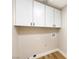 Practical laundry room with white cabinets, wood floors, and utility connections at 10017 Snow Crest Pl, Las Vegas, NV 89134
