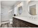 Modern bathroom features a double sink vanity, marble countertop, dark wood cabinets and glass shower with marble tile at 10046 Floragold Ct, Las Vegas, NV 89147