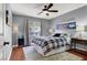 Cozy bedroom with soft gray walls, a ceiling fan, wood floors, stylish furniture, and a serene atmosphere at 10046 Floragold Ct, Las Vegas, NV 89147