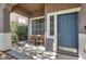 Inviting covered front porch with seating and a blue front door at 10046 Floragold Ct, Las Vegas, NV 89147
